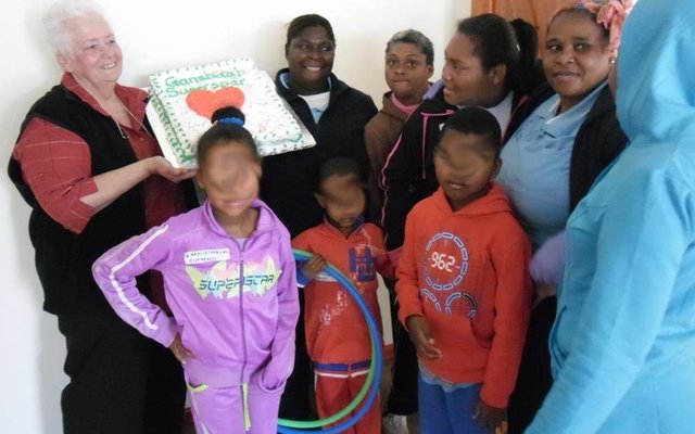 ‘n Deel van die kinders in die Gansbaai Huis wat nie kon wag vir die koek om gesny te word nie, met Joanne Swart wat Gansbaai Superspar se koek houvas. Die kinders se gesiggies word op die foto's verskuil om hul identitiet te beskerm.
